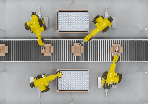 Four robotic machines working together to pack items into cardboard boxes along a conveyor belt.